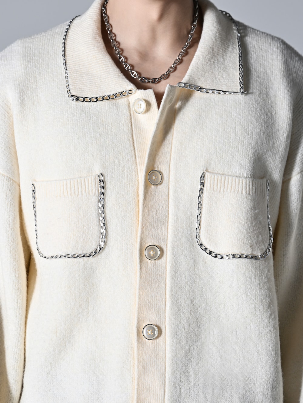 ブラック系のスラックス、ブラック系のローファー、ホワイト系のカーディガン/ボレロを着用したメンズの秋コーディネートの2枚目の写真