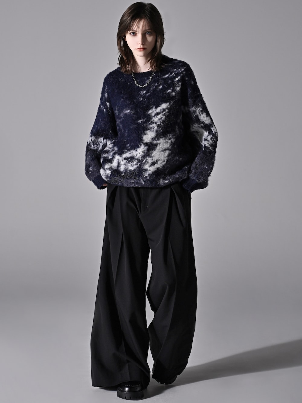 ブルー系のニット/セーター、グレー系のデニムパンツ、ブラック系のショルダーバッグを着用したメンズの秋コーディネートの4枚目の写真