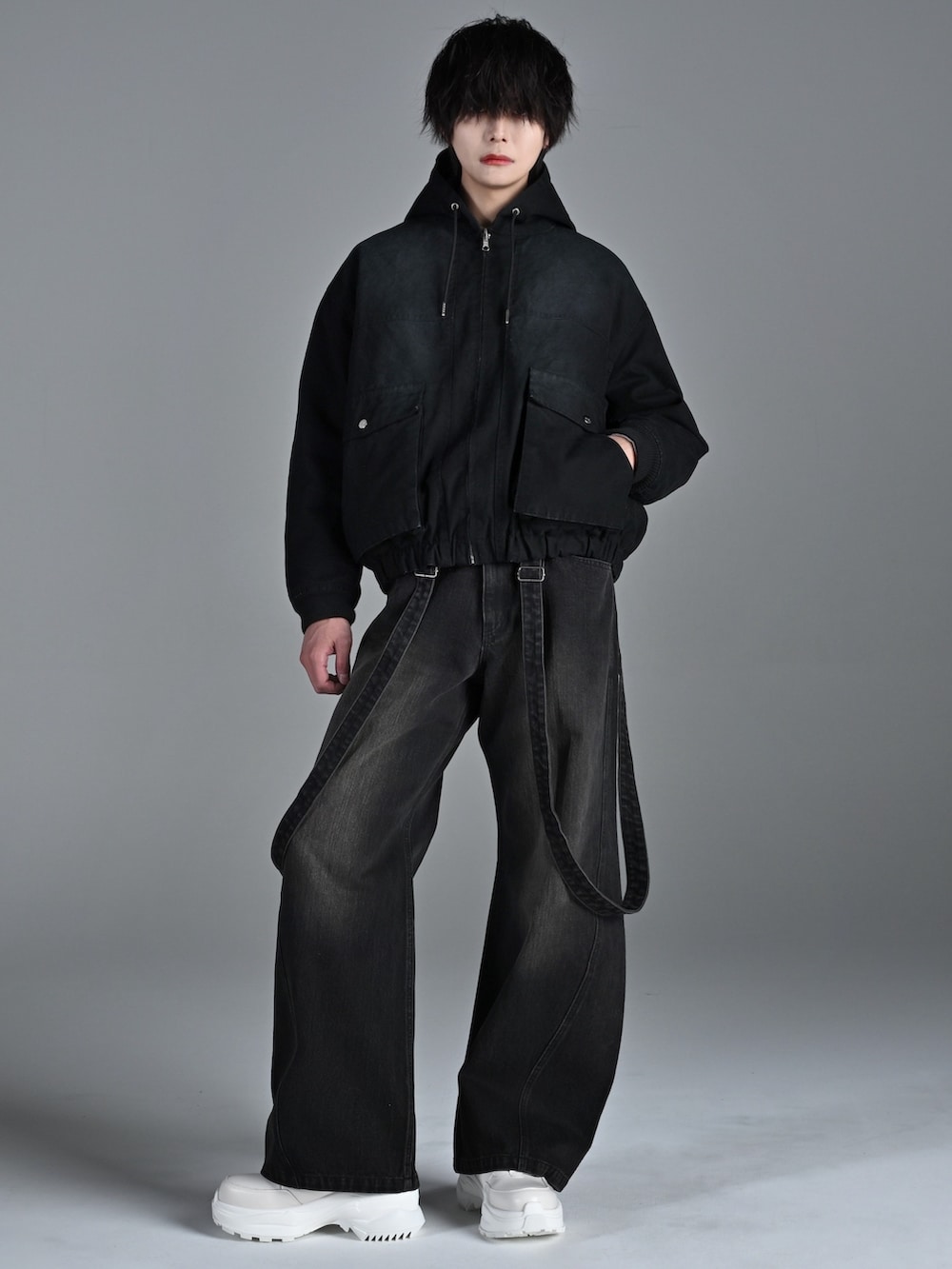 ホワイト系のスニーカー、ブラック系のブルゾン、グレー系のスウェットを着用したメンズの冬コーディネートの2枚目の写真