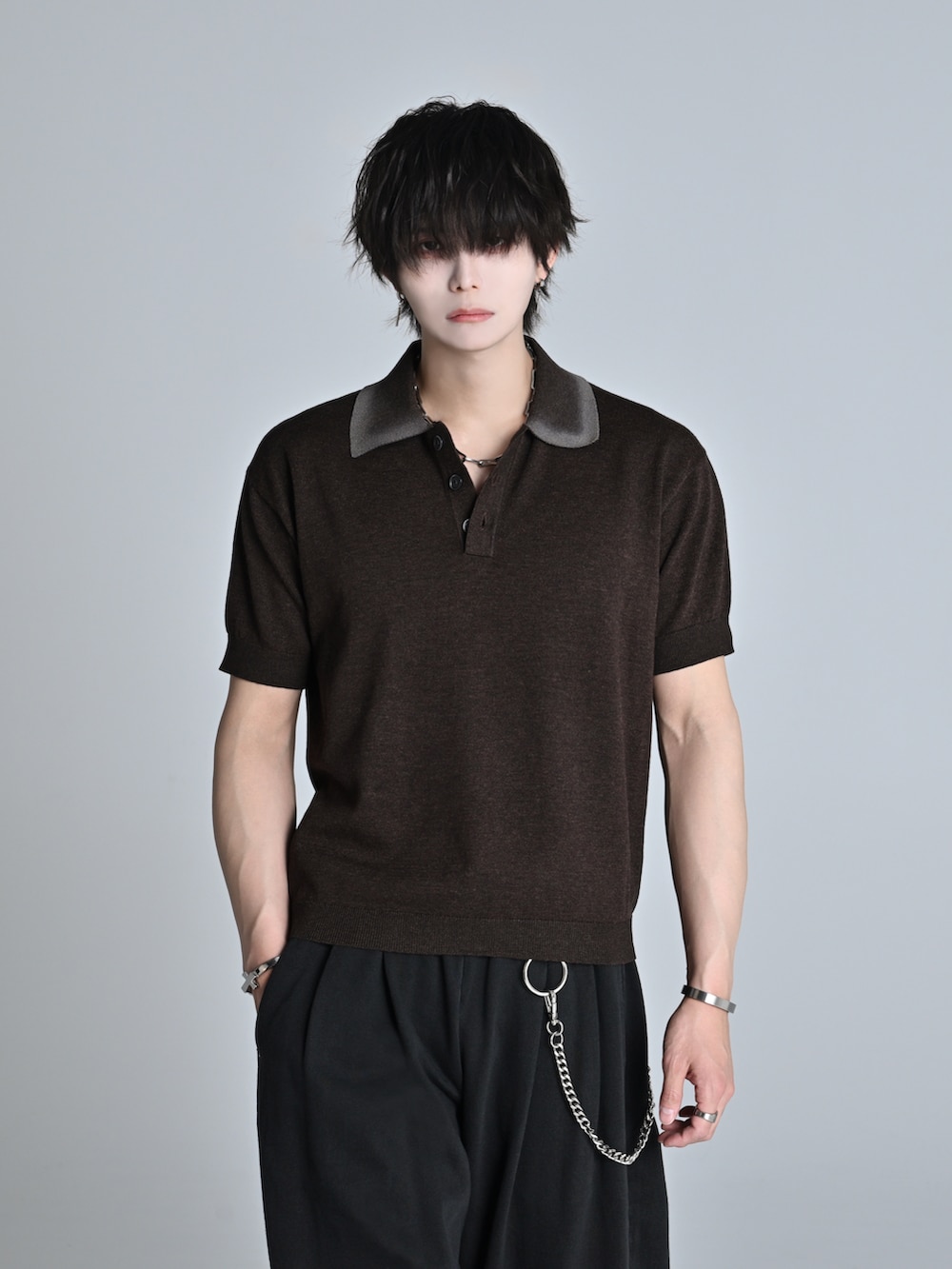 ブラウン系のポロシャツ、ブラック系のスウェットパンツ、ブラック系のショルダーバッグを着用したメンズの春コーディネートの2枚目の写真