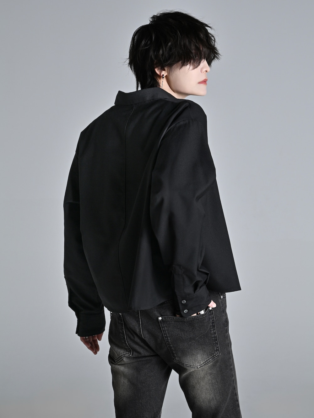 ブラック系のデニムパンツ、ブラック系のショルダーバッグ、ブラック系のスニーカーを着用したメンズの冬コーディネートの3枚目の写真