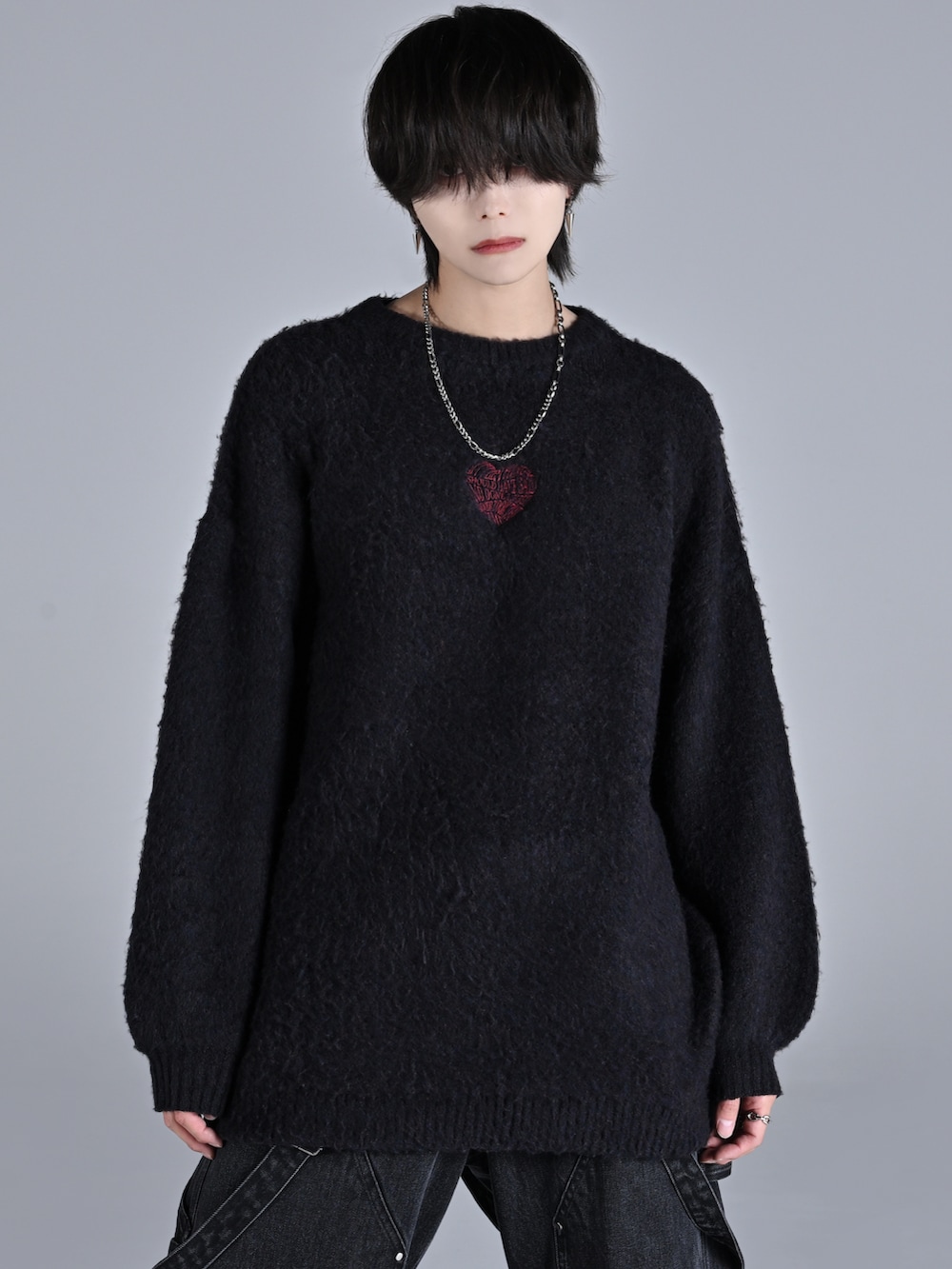 ブラック系のニット/セーター、ブラック系のデニムパンツ、ブラック系のスニーカーを着用したメンズの秋コーディネートの2枚目の写真