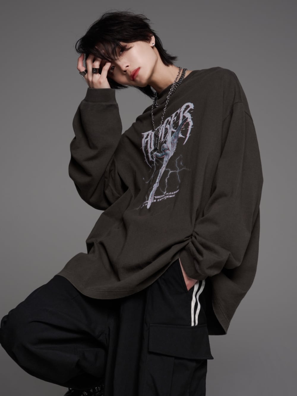 ブラック系のスニーカー、グレー系のTシャツ/カットソー、ホワイト系のカーゴパンツを着用したメンズの秋コーディネートの3枚目の写真