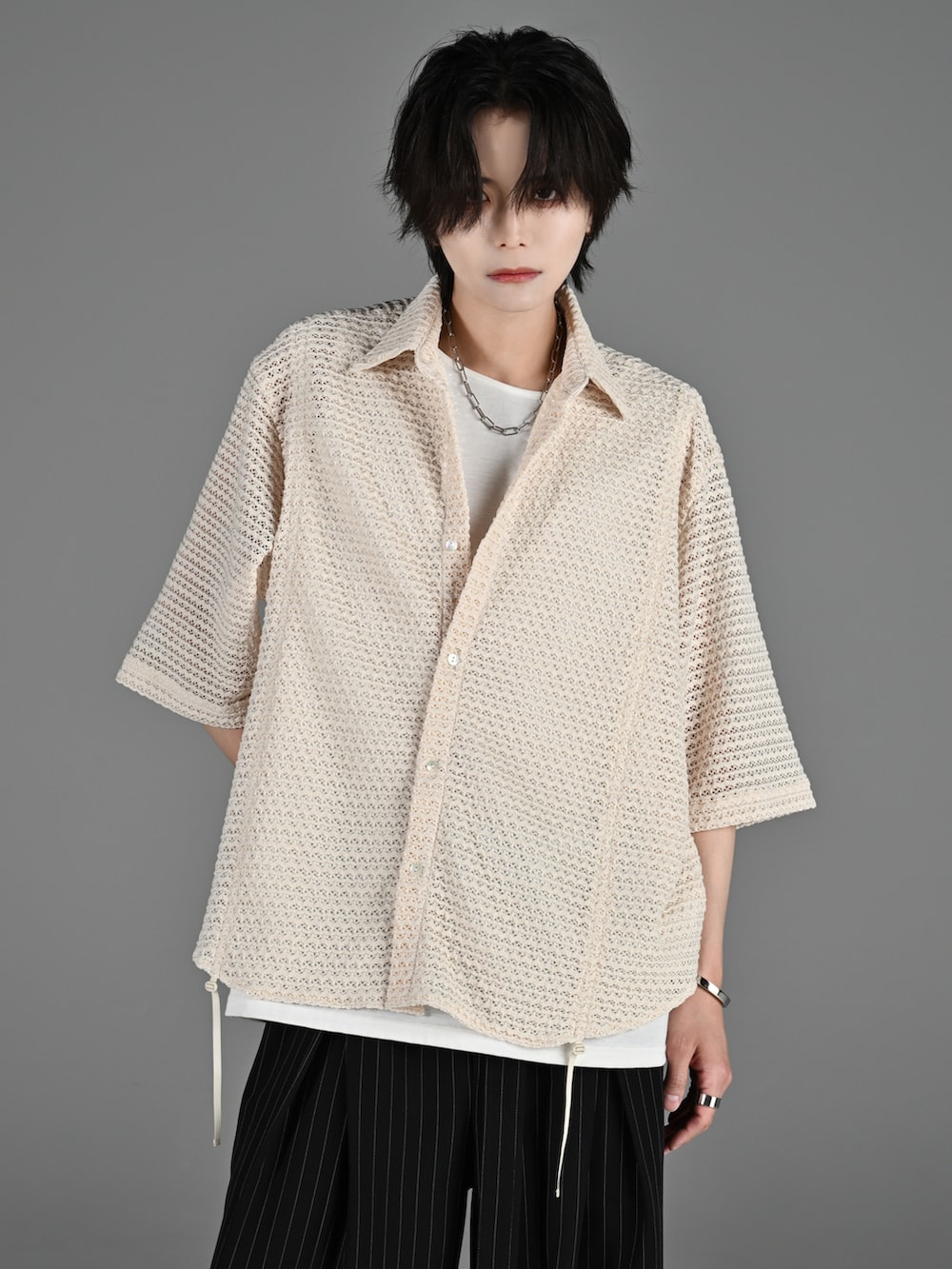 ブラック系のスニーカー、グレー系のタンクトップ、ホワイト系のシャツ/ブラウスを着用したメンズの春コーディネートの4枚目の写真