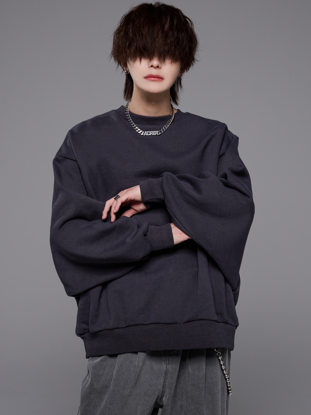 グレー系のデニムパンツ、グレー系のスウェット、ブラック系のブーツを着用したメンズの冬コーディネートの4枚目の写真