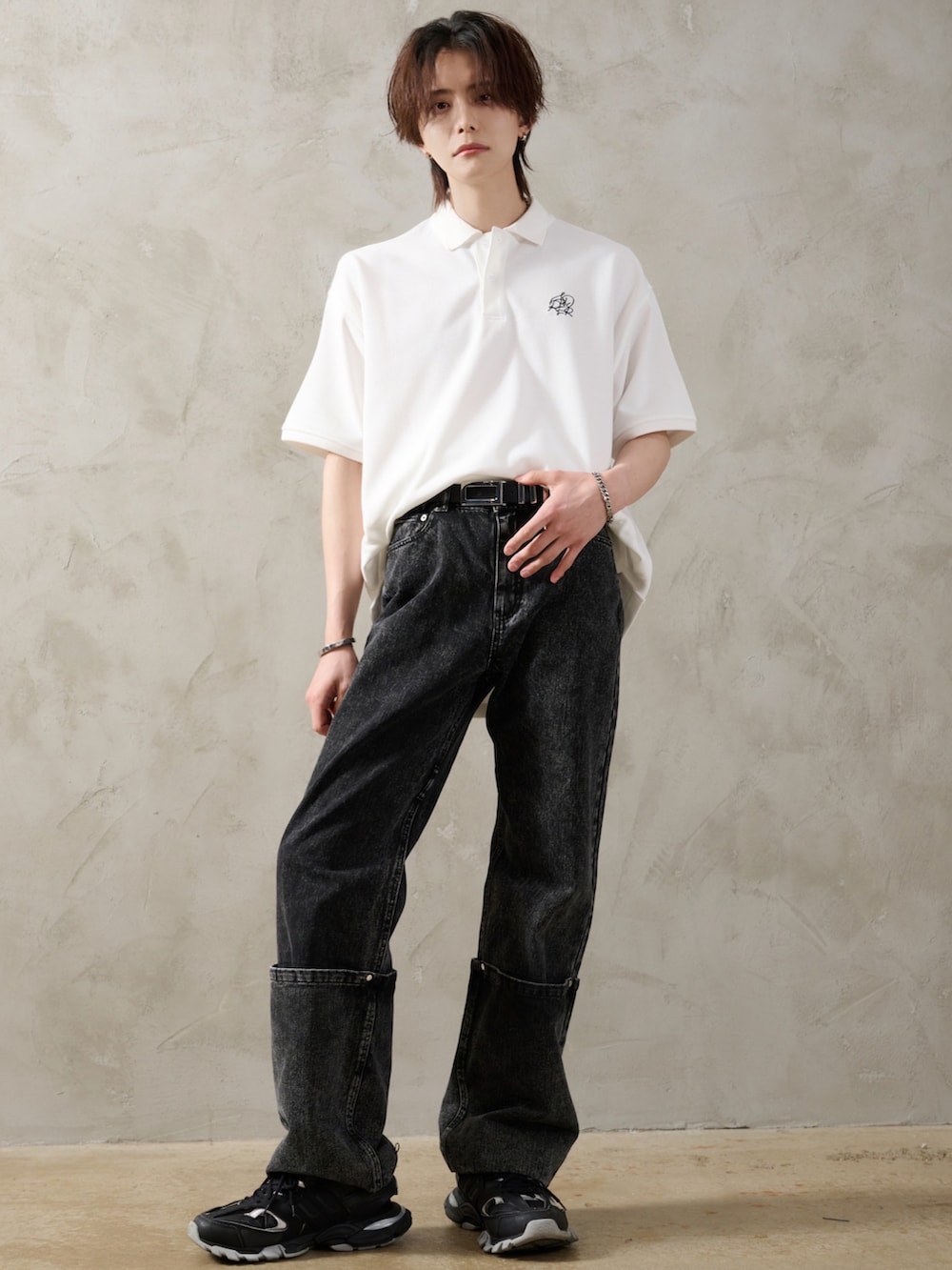 ブラック系のデニムパンツ、ブラック系のショルダーバッグ、ブラック系のスニーカーを着用したメンズの春コーディネートの3枚目の写真