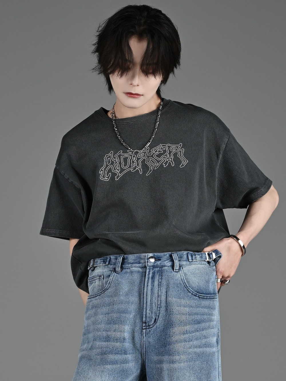 ブラック系のブーツ、グレー系のTシャツ/カットソー、ブルー系のデニムパンツを着用したメンズの春コーディネートの2枚目の写真