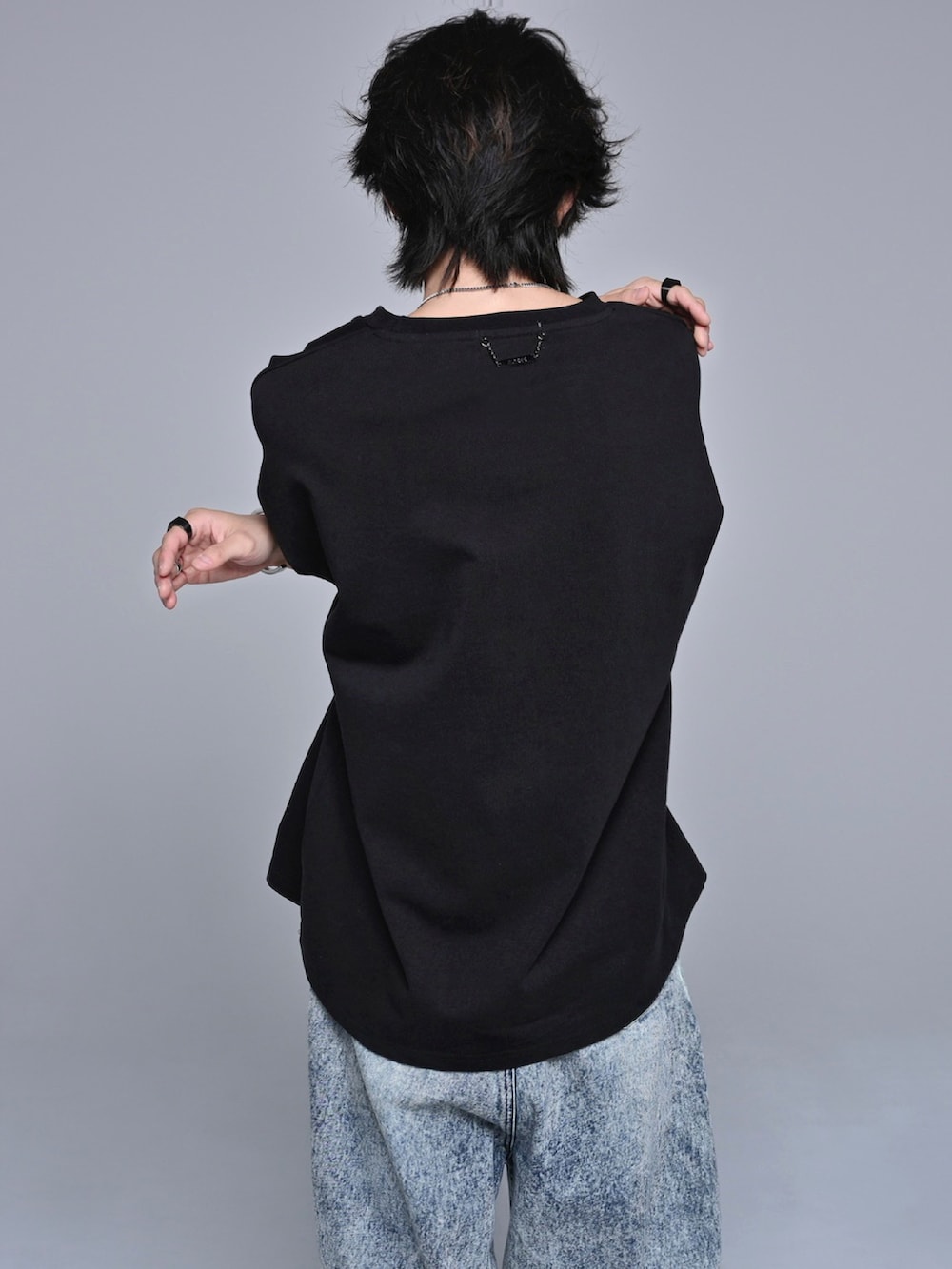 ブルー系のデニムパンツ、ブラック系のスニーカー、ブラック系のTシャツ/カットソーを着用したメンズの春コーディネートの5枚目の写真