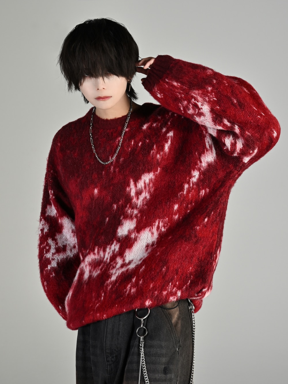 ブラック系のスニーカー、レッド系のニット/セーター、ブラック系のデニムパンツを着用したメンズの秋コーディネートの4枚目の写真