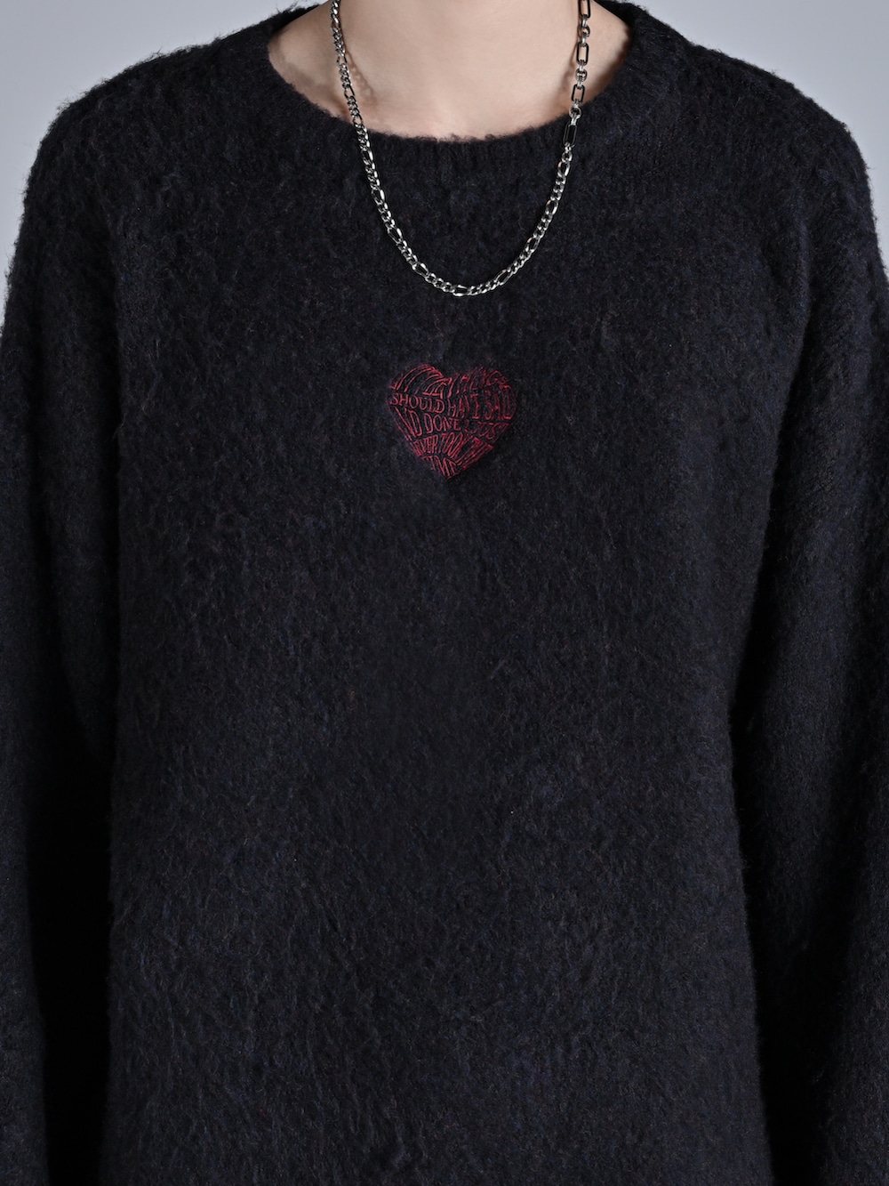 ブラック系のニット/セーター、ブラック系のデニムパンツ、ブラック系のスニーカーを着用したメンズの秋コーディネートの3枚目の写真