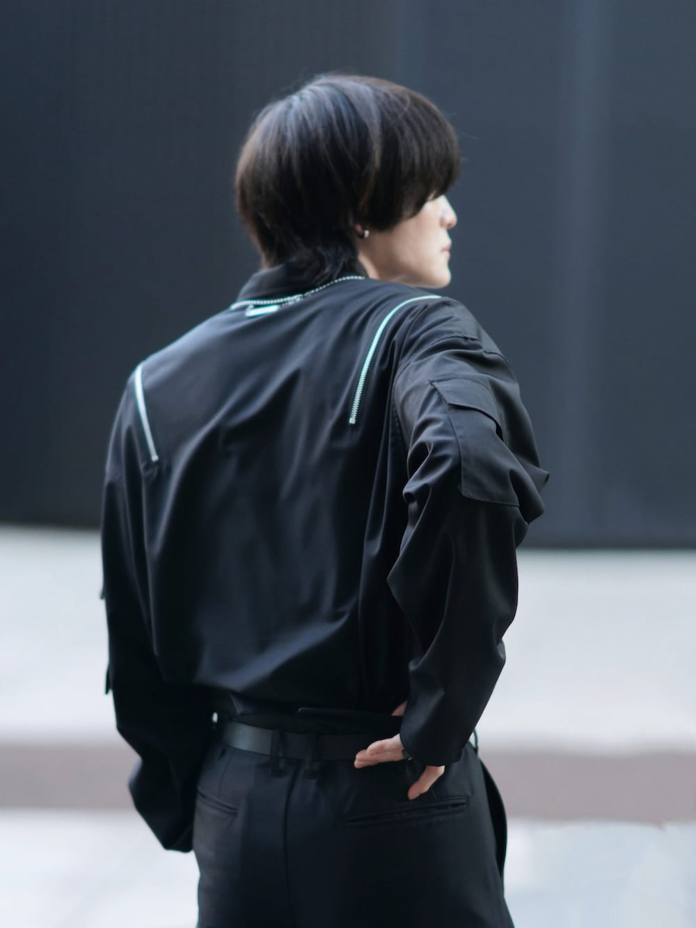 ブラック系のテーラードジャケット、ブラック系のスニーカー、ブラック系のその他アウターを着用したメンズの冬コーディネートの5枚目の写真