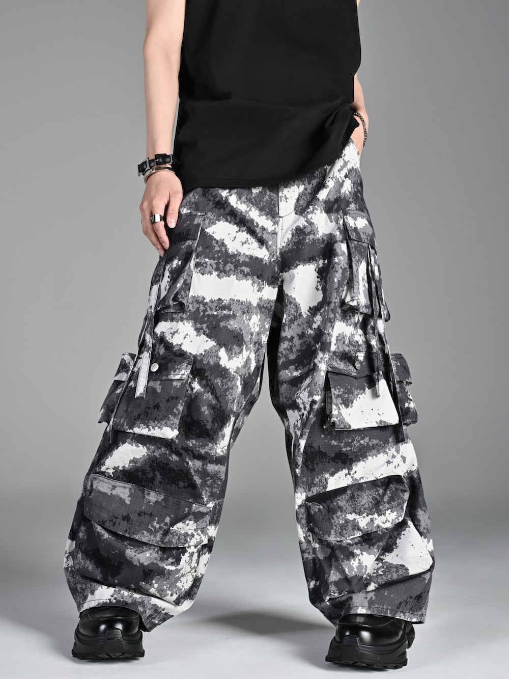 レッド系のタンクトップ、ブラック系のスニーカー、ブラック系のショルダーバッグを着用したメンズの夏コーディネートの2枚目の写真