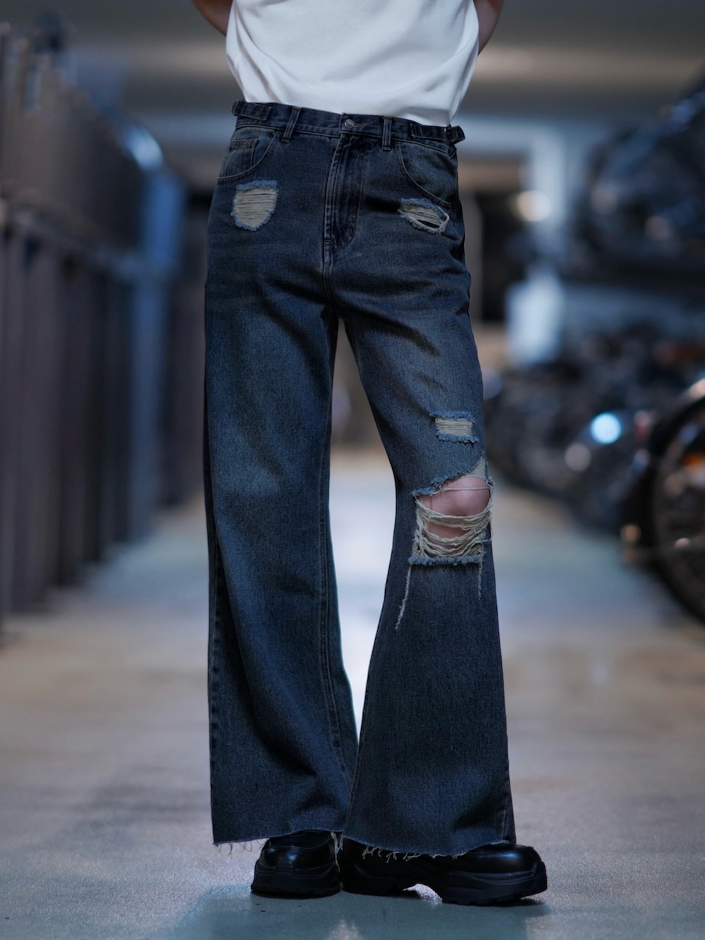 ブラック系のスニーカー、ホワイト系のTシャツ/カットソー、ブルー系のデニムパンツを着用したメンズの春コーディネートの4枚目の写真