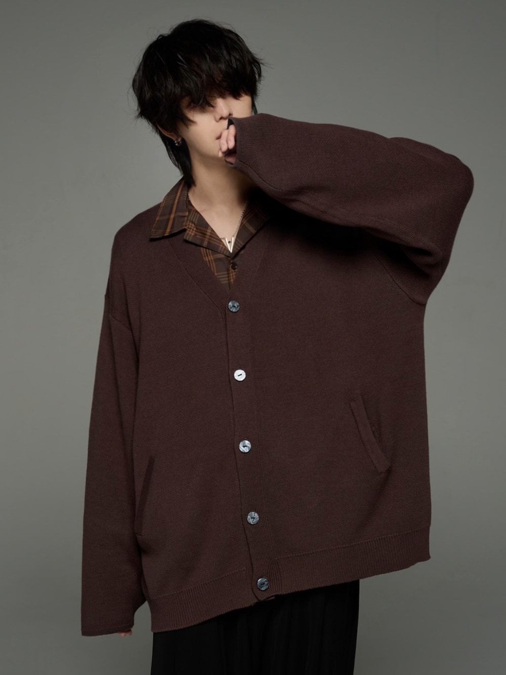 ブラック系のスラックス、ブラック系のブーツ、ブラウン系のカーディガン/ボレロを着用したメンズの秋コーディネートの2枚目の写真