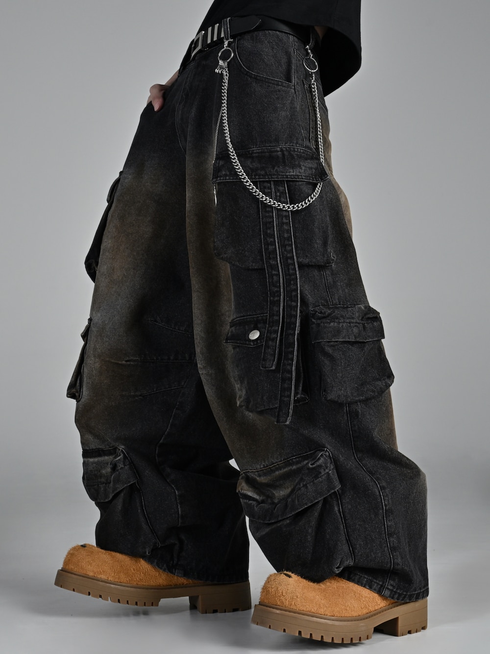 ブラウン系のブルゾン、ベージュ系のブーツ、ブラック系のカーゴパンツを着用したメンズの秋コーディネートの3枚目の写真