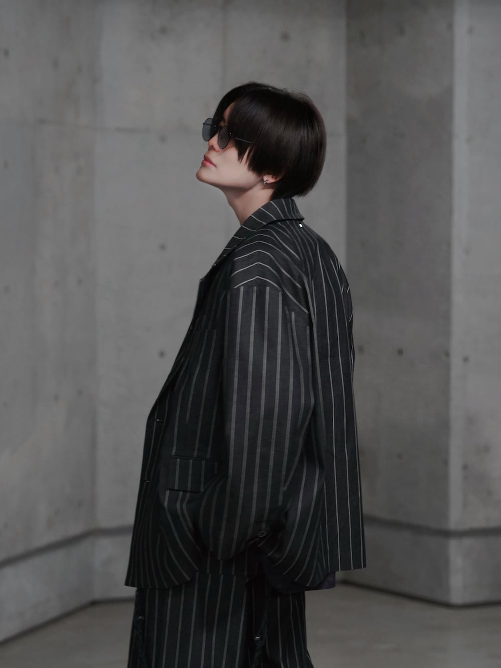 ブラック系のブーツ、ブラック系のテーラードジャケット、ブラック系のスラックスを着用したメンズの冬コーディネートの3枚目の写真