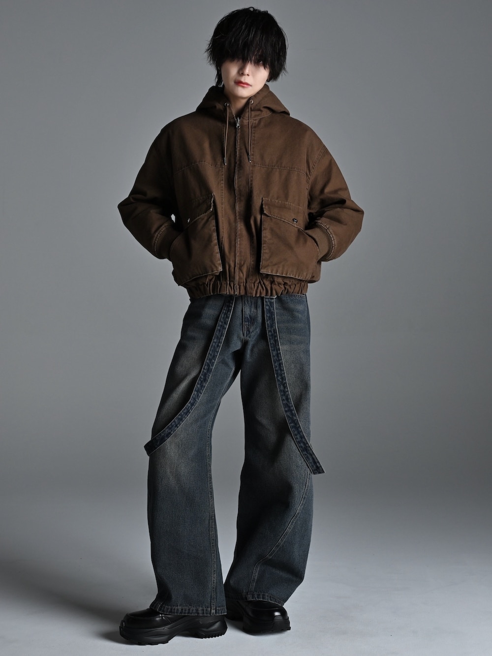 ブラック系のスニーカー、ブラウン系のブルゾン、グレー系のスウェットを着用したメンズの冬コーディネートの2枚目の写真