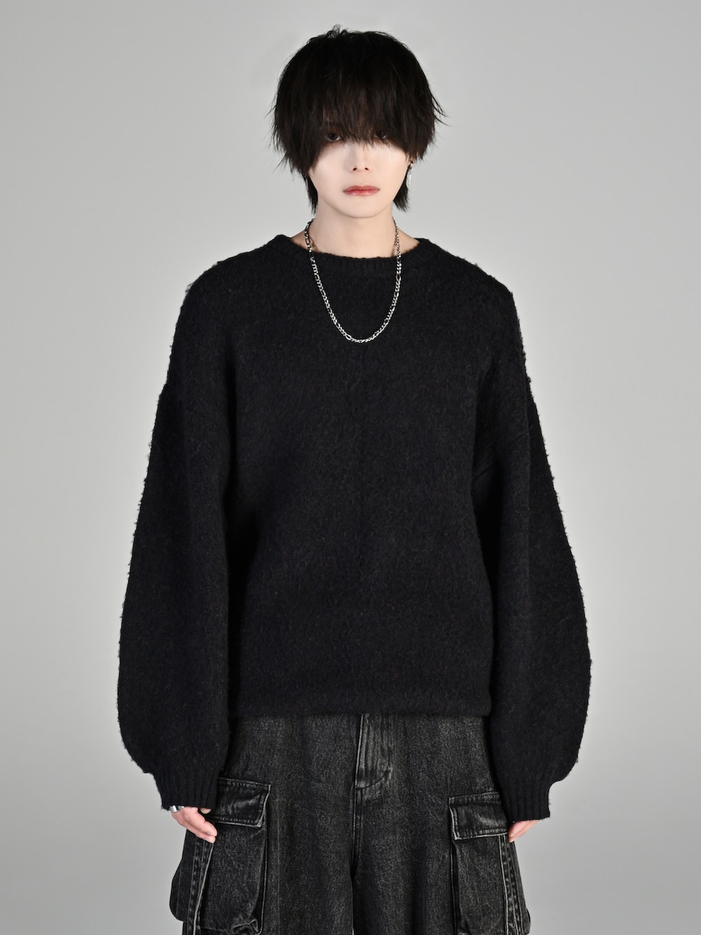 ブラック系のカーゴパンツ、ブラック系のローファー、ブラック系のニット/セーターを着用したメンズの秋コーディネートの3枚目の写真