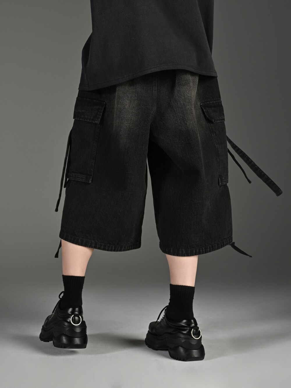 ホワイト系のスニーカー、ブラック系のTシャツ/カットソー、ブラック系のカーゴパンツを着用したメンズの春コーディネートの5枚目の写真