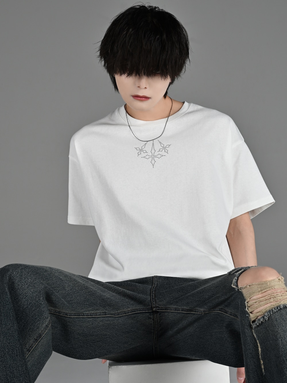 ブラック系のブーツ、ホワイト系のTシャツ/カットソー、ブルー系のデニムパンツを着用したメンズの春コーディネートの3枚目の写真