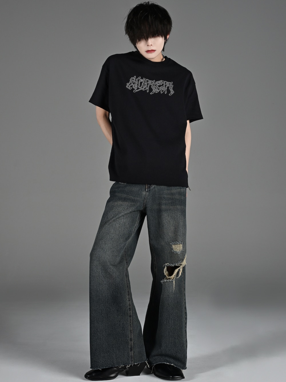 ブラック系のスニーカー、ブラック系のTシャツ/カットソー、ブラック系のデニムパンツを着用したメンズの春コーディネートの4枚目の写真