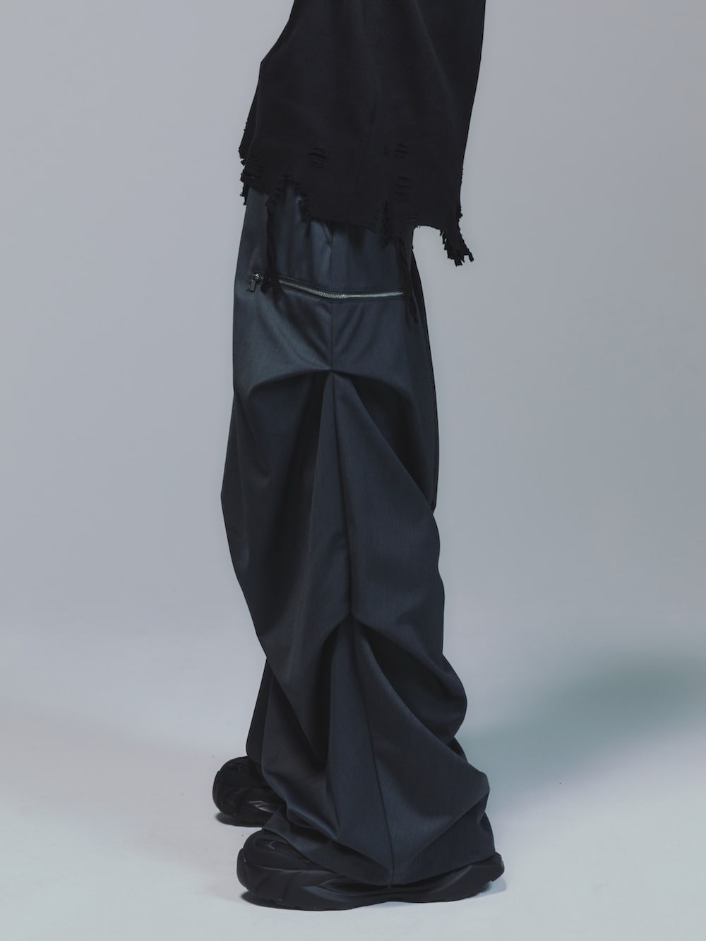 ブラック系のパーカー、レッド系のタンクトップ、ブラック系のスラックスを着用したメンズの秋コーディネートの4枚目の写真