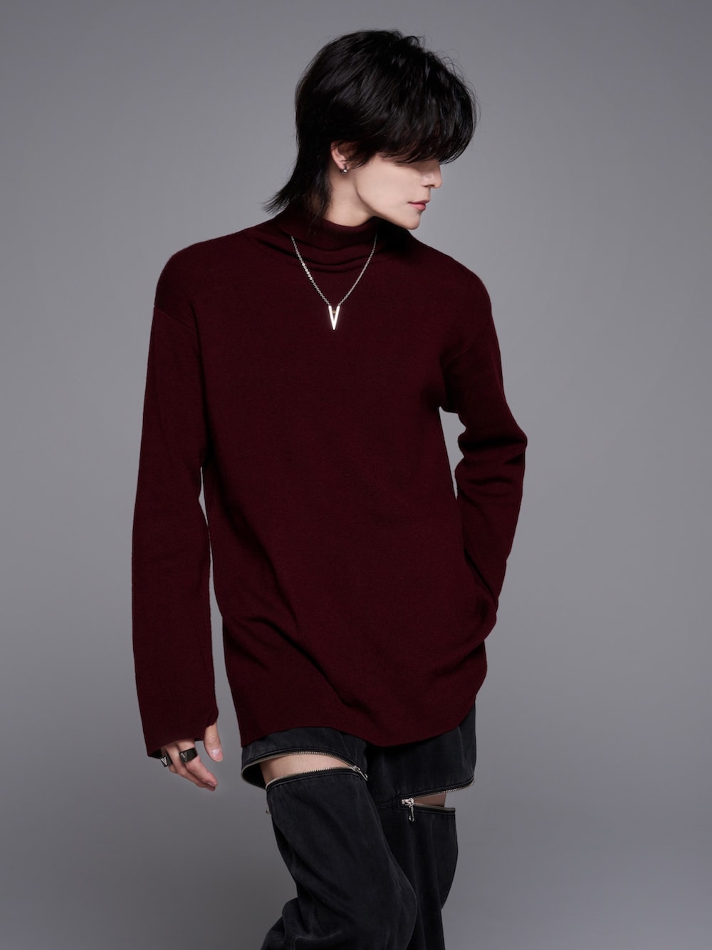 ブラック系のスニーカー、ブラック系のニット/セーター、グレー系のデニムパンツを着用したメンズの秋コーディネートの5枚目の写真