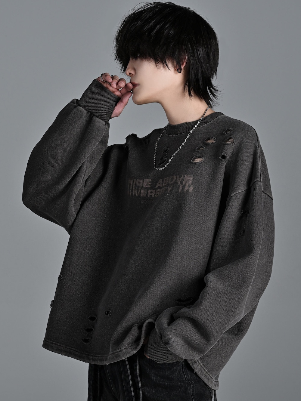 ブラウン系のスウェット、ブラック系のデニムパンツ、シルバー系のネックレスを着用したメンズの冬コーディネートの3枚目の写真