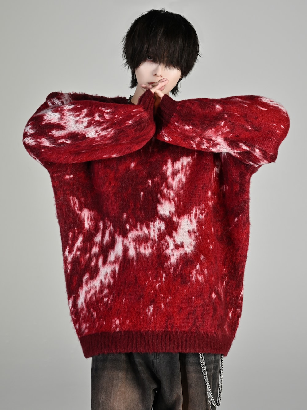 ブラック系のスニーカー、レッド系のニット/セーター、ブラック系のデニムパンツを着用したメンズの秋コーディネートの2枚目の写真