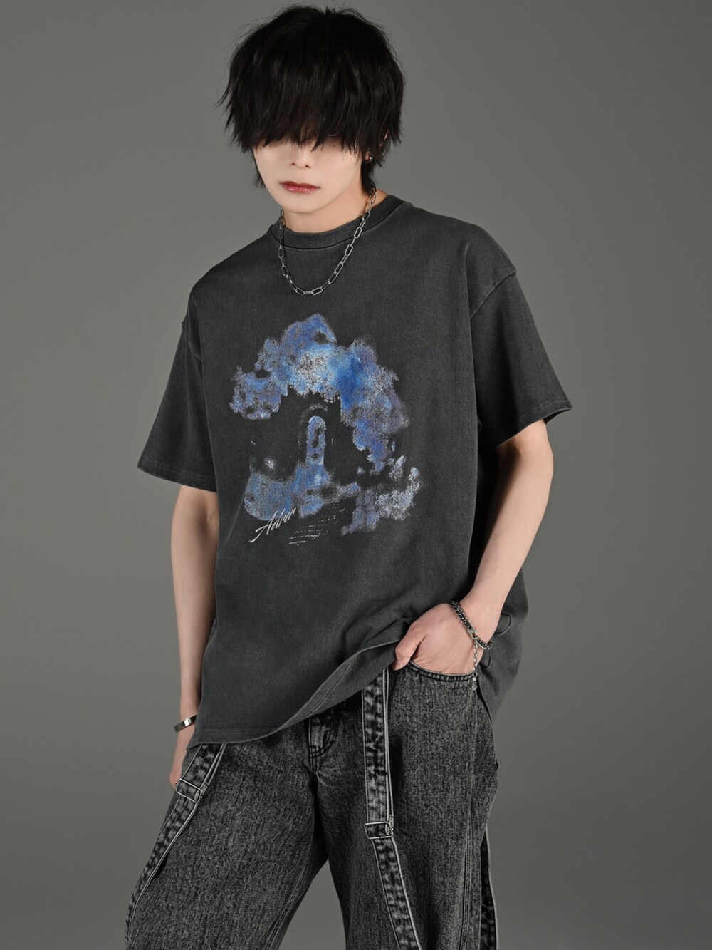 ブラック系のデニムパンツ、ブラック系のブーツ、グレー系のTシャツ/カットソーを着用したメンズの春コーディネートの2枚目の写真