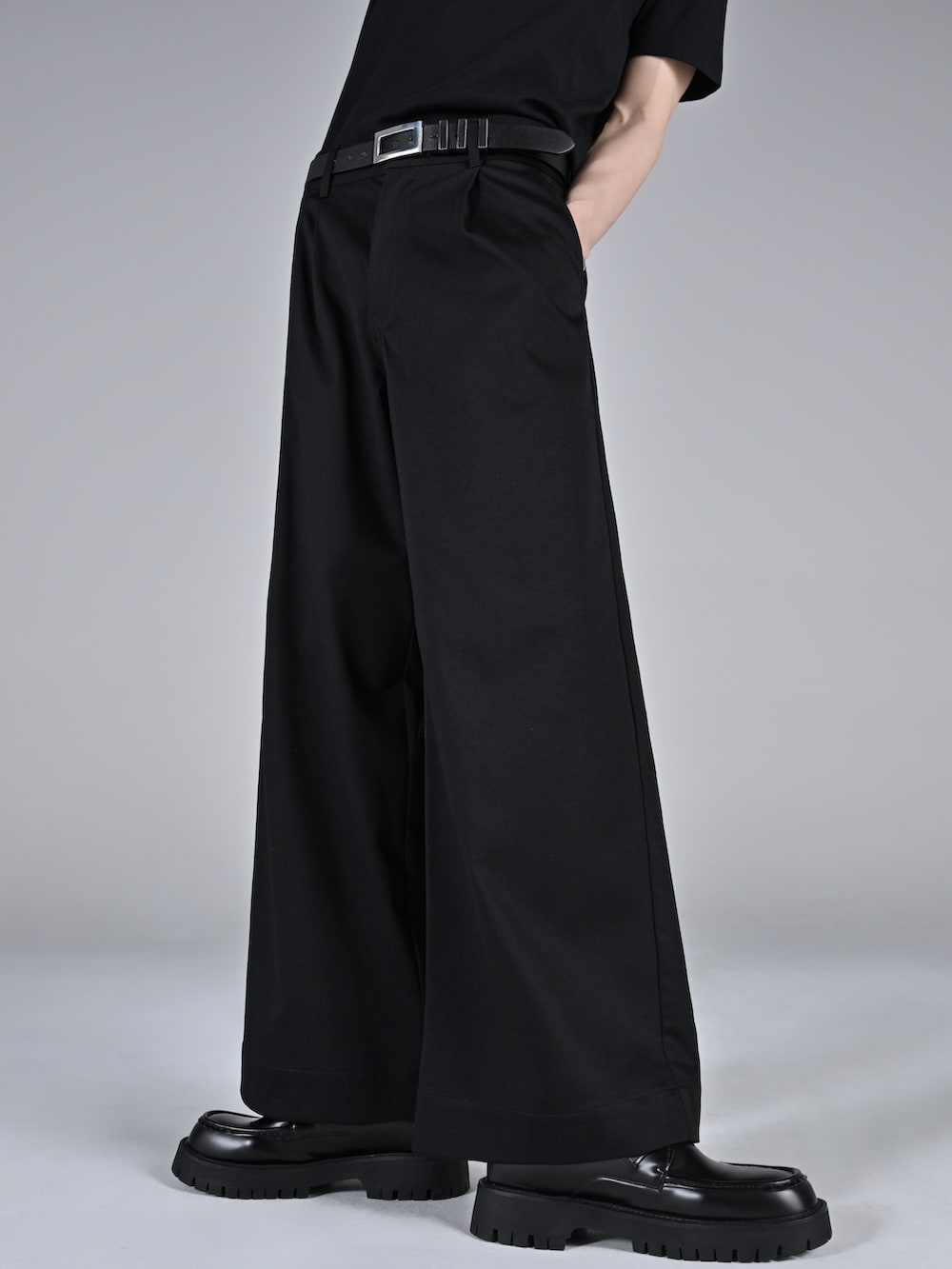 ブラック系のテーラードジャケット、レッド系のタンクトップ、ブラック系のスラックスを着用したメンズの冬コーディネートの5枚目の写真