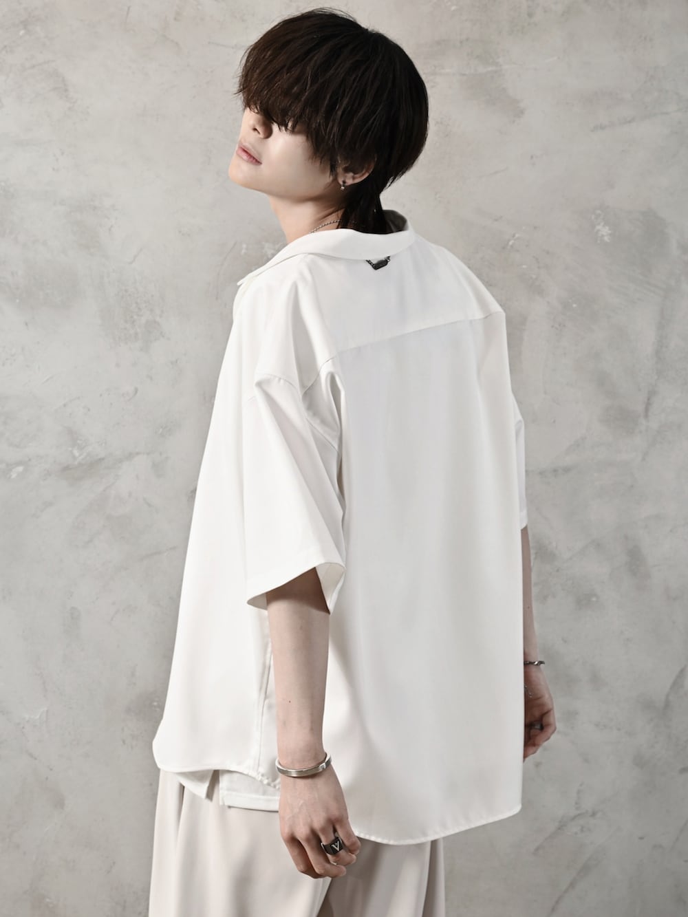 ホワイト系のタンクトップ、ホワイト系のスラックス、ブラック系のショルダーバッグを着用したメンズの春コーディネートの3枚目の写真