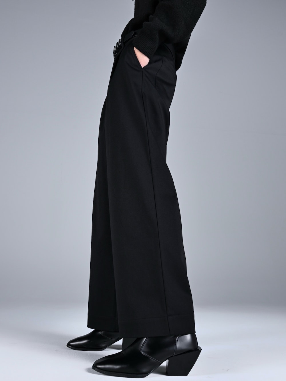 ブラック系のブーツ、ブラック系のニット/セーター、ブラック系のスラックスを着用したメンズの秋コーディネートの4枚目の写真