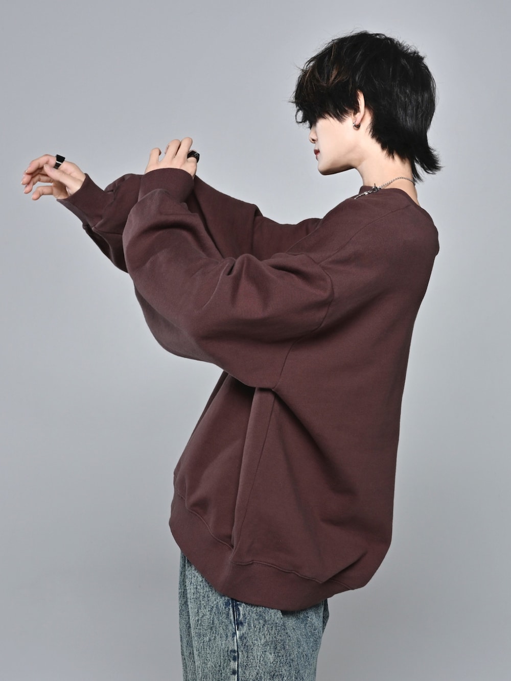 ホワイト系のスニーカー、ブラウン系のスウェット、ベージュ系のデニムパンツを着用したメンズの冬コーディネートの4枚目の写真