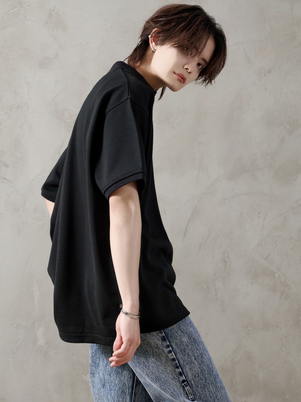 ブルー系のデニムパンツ、ブラック系のブーツ、ブラック系のポロシャツを着用したメンズの春コーディネートの4枚目の写真