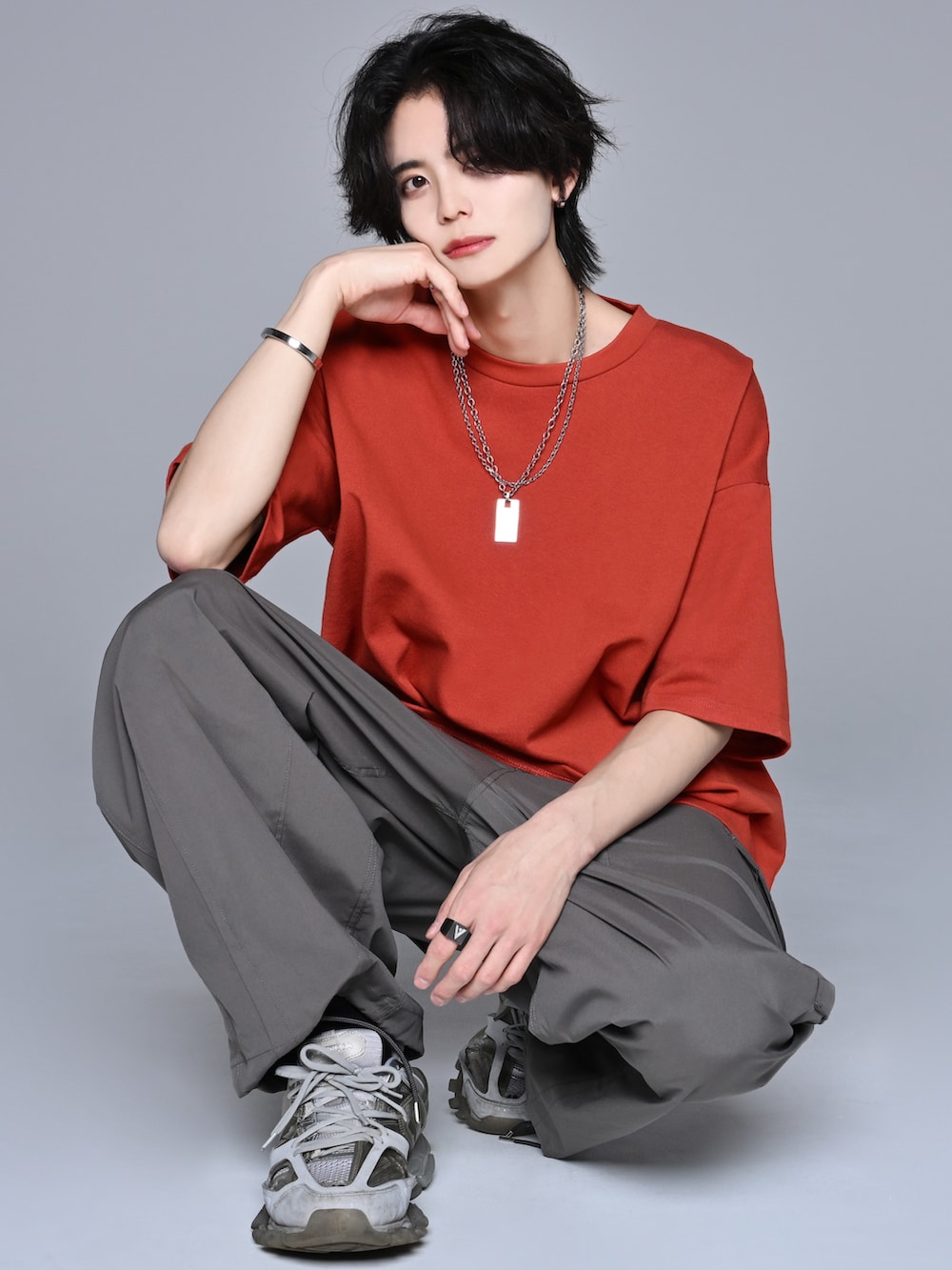 グレー系のカーゴパンツ、グレー系のスニーカー、ブラウン系のTシャツ/カットソーを着用したメンズの春コーディネートの2枚目の写真