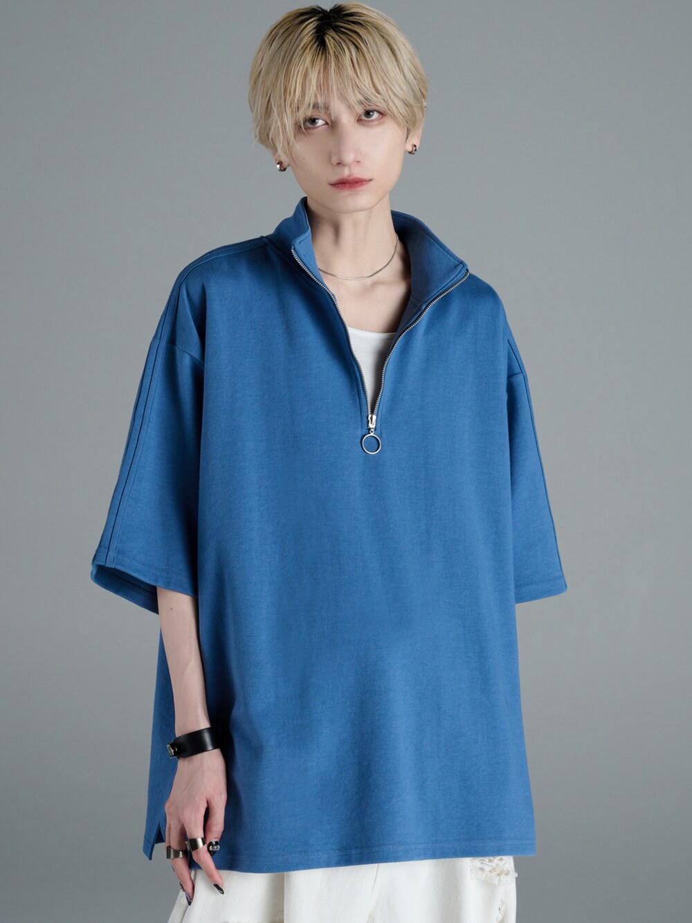 ブラック系のデニムパンツ、ホワイト系のスニーカー、ブラック系のショルダーバッグを着用したメンズの春コーディネートの2枚目の写真