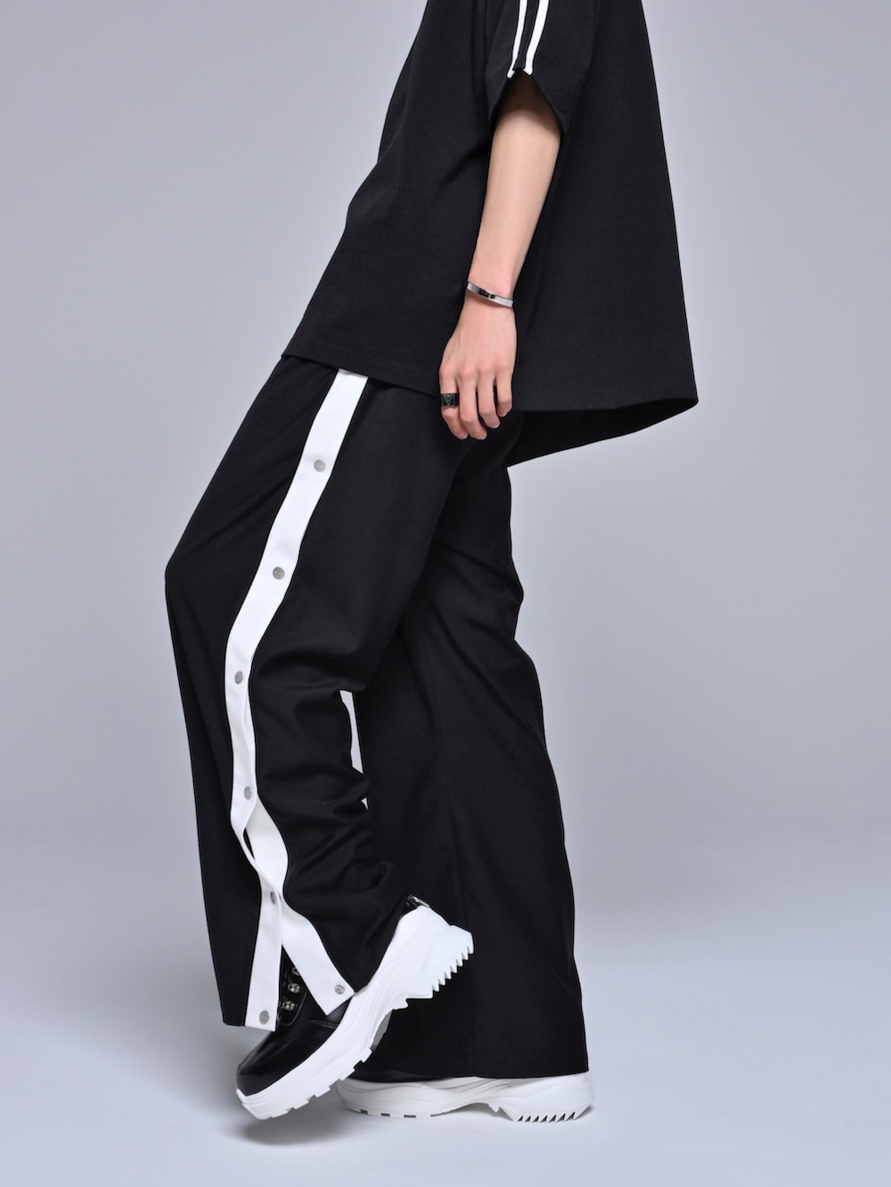 ブラック系のスニーカー、ブラック系のその他パンツ、ブラック系のTシャツ/カットソーを着用したメンズの春コーディネートの3枚目の写真