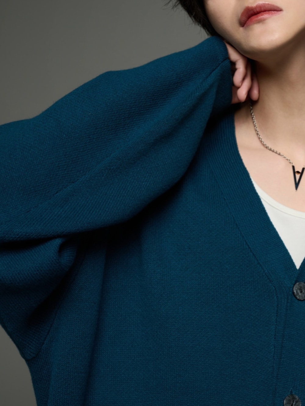 ブラック系のデニムパンツ、ブラック系のブーツ、グリーン系のカーディガン/ボレロを着用したメンズの秋コーディネートの4枚目の写真