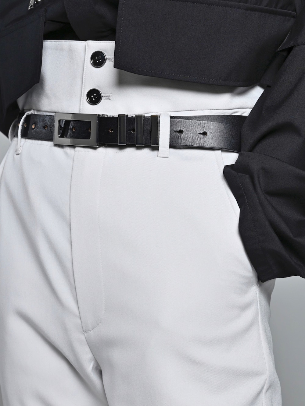 ブラック系のブーツ、ブラック系のその他アウター、グレー系のスラックスを着用したメンズの冬コーディネートの3枚目の写真