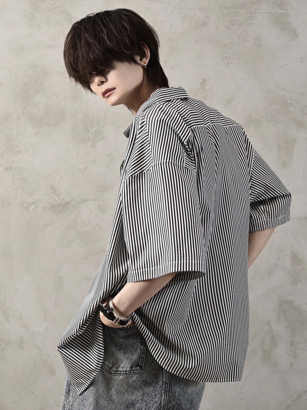 ブルー系のデニムパンツ、ホワイト系のシャツ/ブラウス、ブラック系のサンダルを着用したメンズの夏コーディネートの3枚目の写真