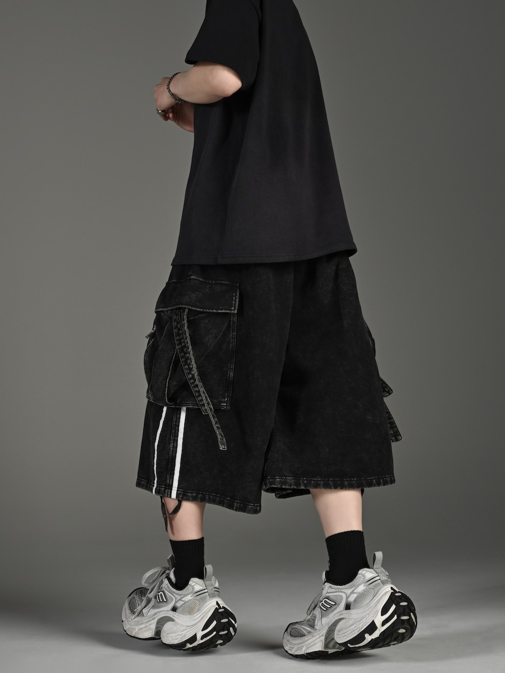 ブラック系のスニーカー、ブラック系のショルダーバッグ、ブラック系のTシャツ/カットソーを着用したメンズの春コーディネートの4枚目の写真