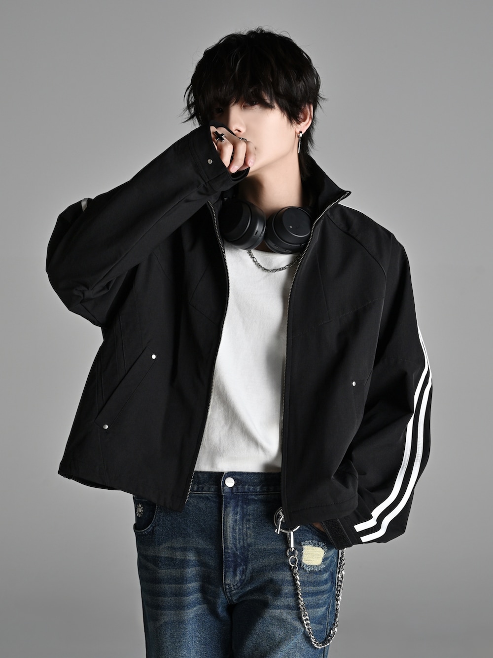 ブラック系のスニーカー、ブラック系のショルダーバッグ、ブラック系のナイロンジャケットを着用したメンズの冬コーディネートの2枚目の写真