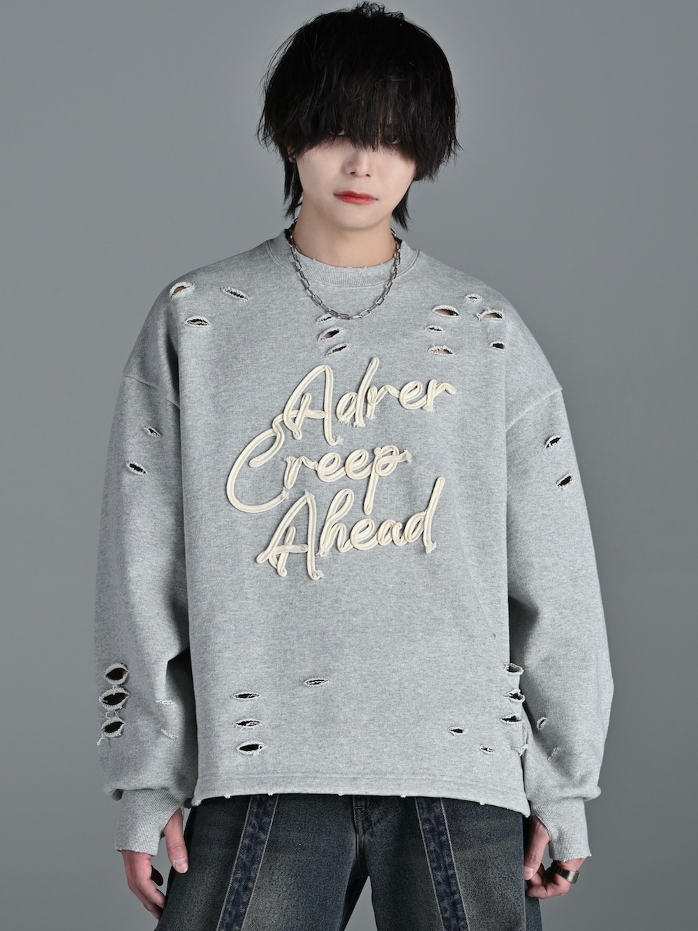 ホワイト系のスニーカー、グレー系のスウェット、ブルー系のデニムパンツを着用したメンズの冬コーディネートの3枚目の写真