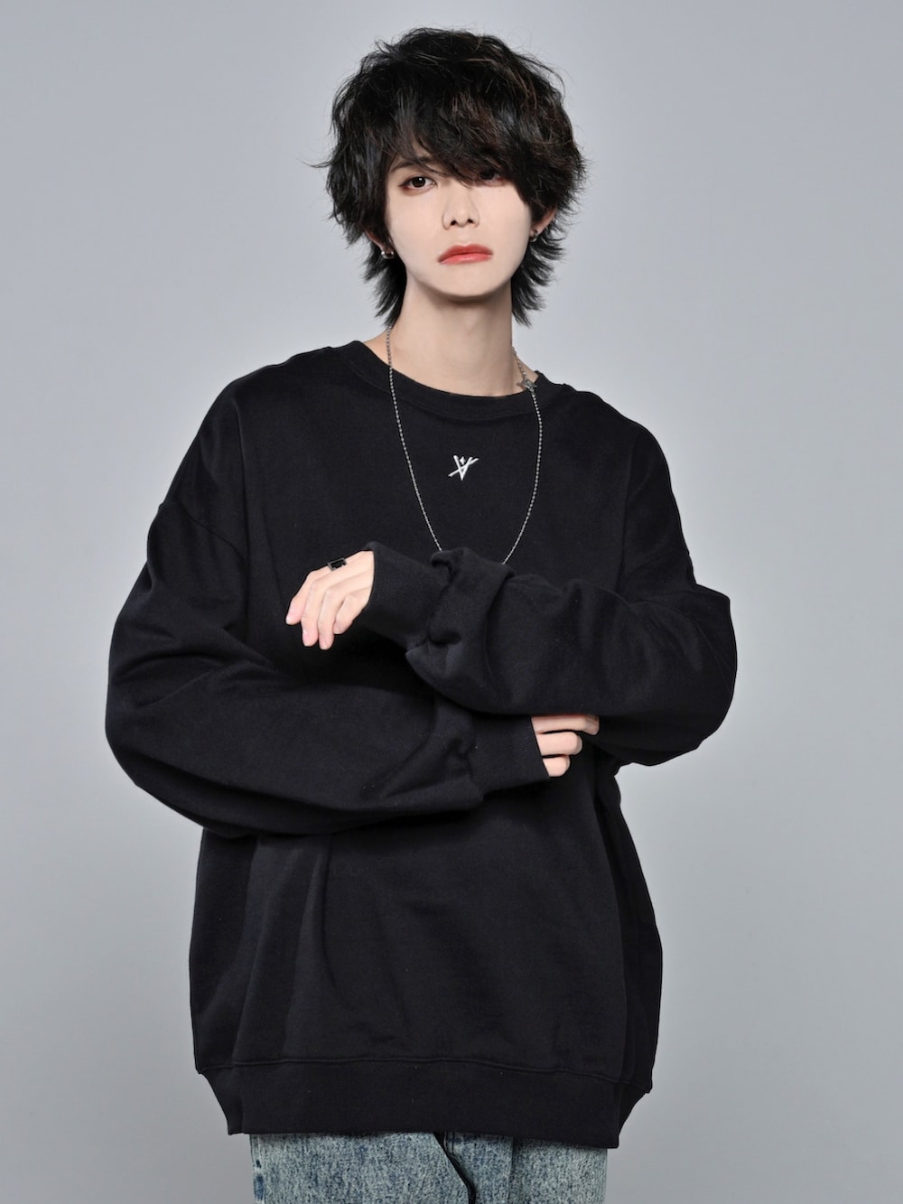 ブラック系のスウェット、ベージュ系のデニムパンツ、ブラック系のスニーカーを着用したメンズの冬コーディネートの3枚目の写真