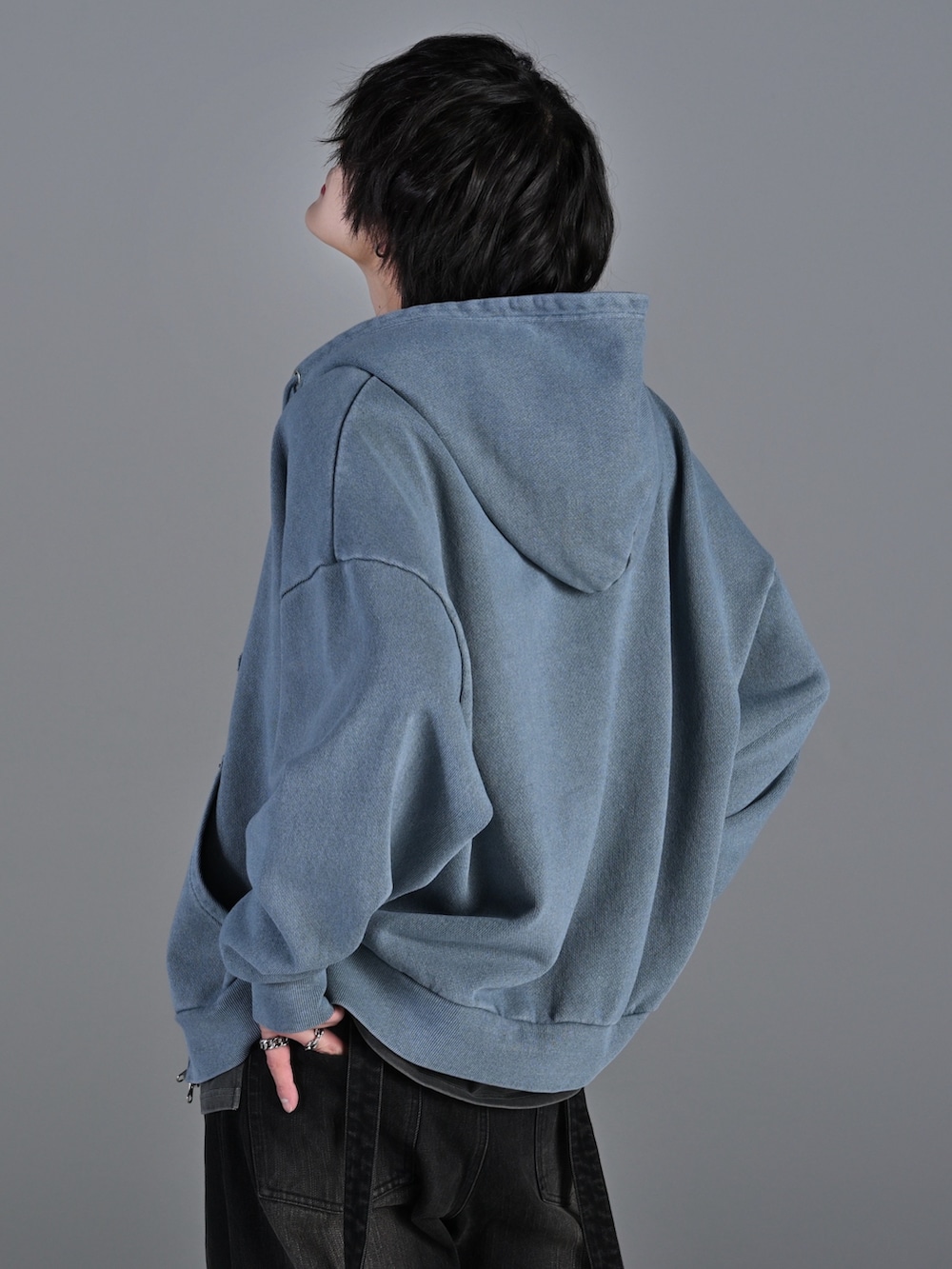 ブラック系のデニムパンツ、ホワイト系のスニーカー、ブラック系のショルダーバッグを着用したメンズの冬コーディネートの4枚目の写真