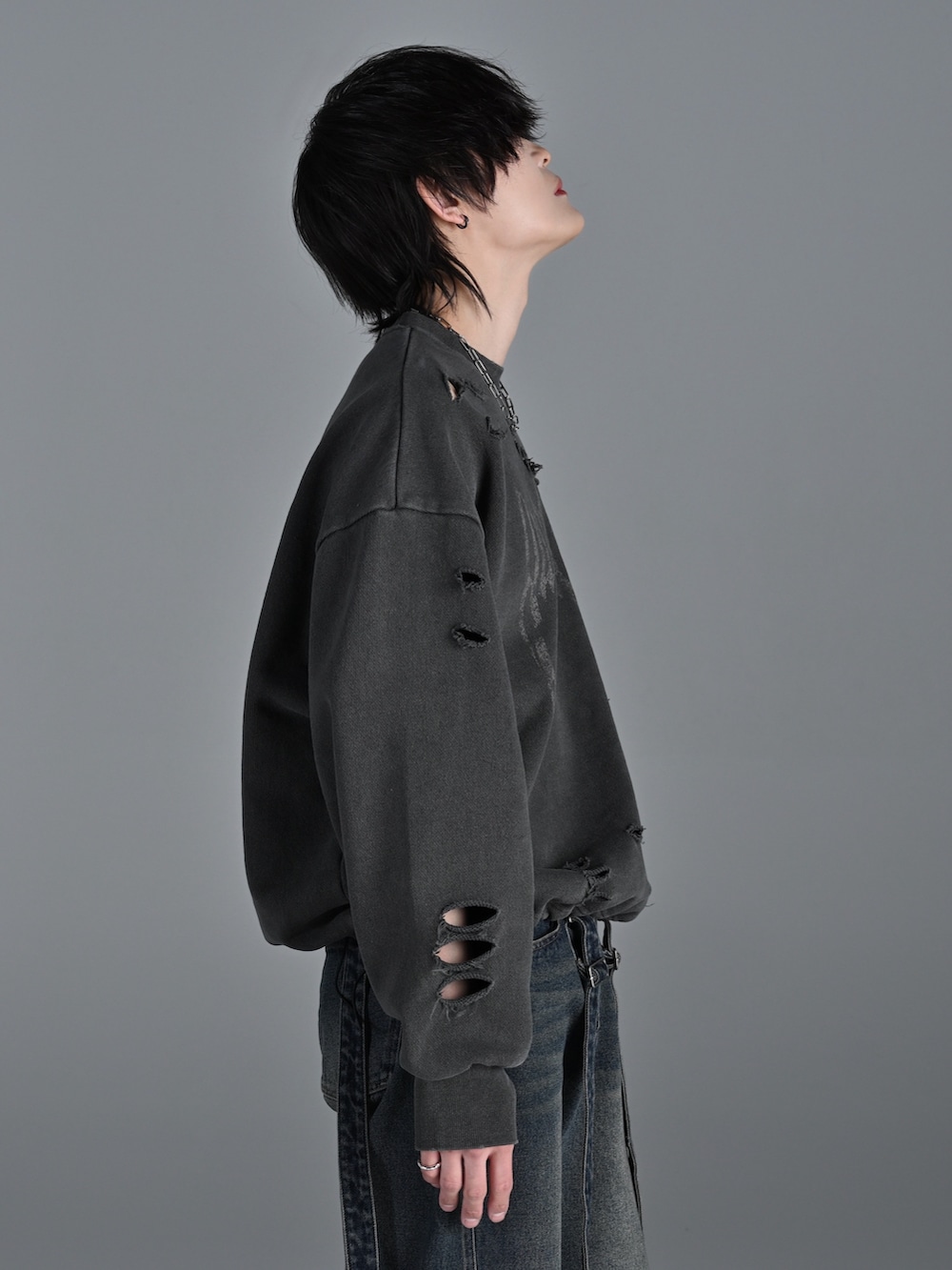 ブラック系のスニーカー、ブルー系のデニムパンツ、グレー系のスウェットを着用したメンズの冬コーディネートの5枚目の写真