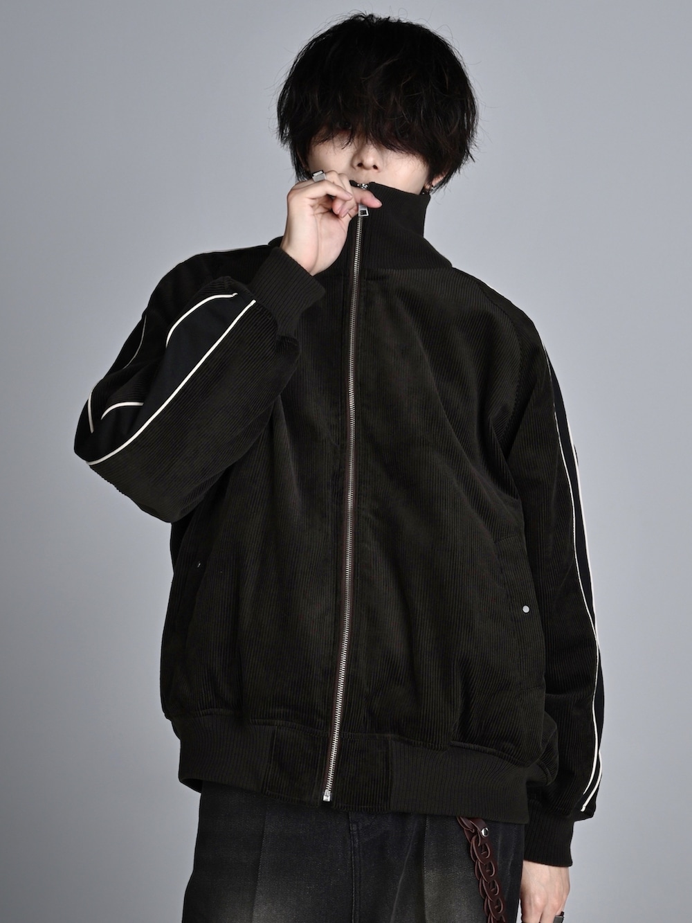 ホワイト系のスニーカー、ブラック系のその他パンツ、ブラウン系のブルゾンを着用したメンズの秋コーディネートの4枚目の写真