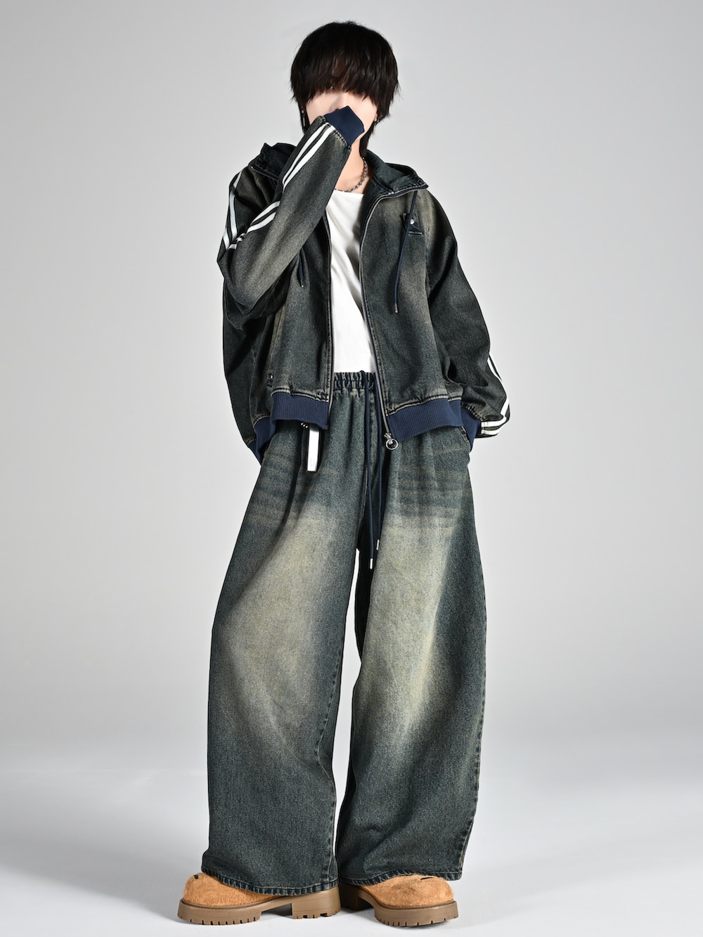 グレー系のタンクトップ、グレー系のカーゴパンツ、ホワイト系のスニーカーを着用したメンズの夏コーディネートの4枚目の写真