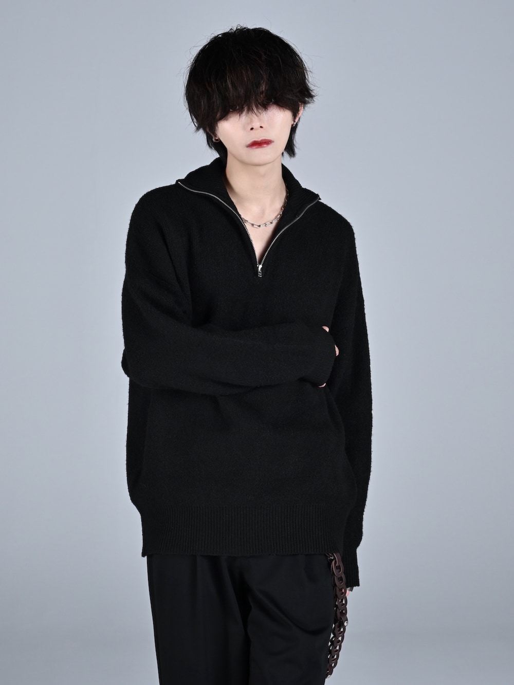 ブラック系のブーツ、ブラック系のニット/セーター、ブラック系のスラックスを着用したメンズの秋コーディネートの3枚目の写真